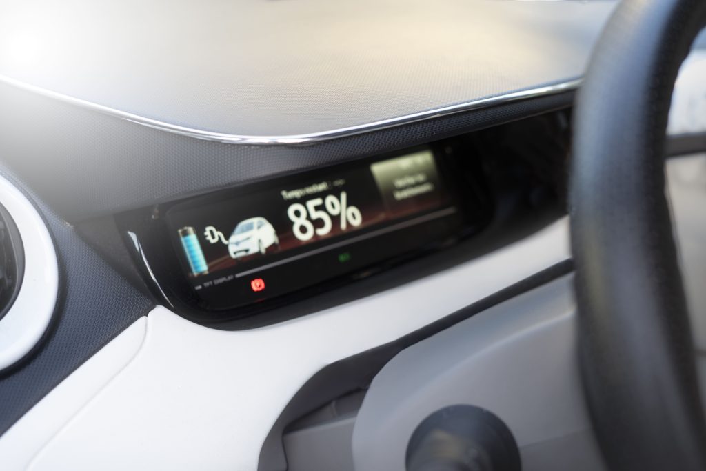 The electric vehicle dashboard displays the charging speed and charging status.