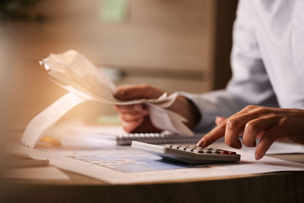 A man is holding a calculator and counting bills.