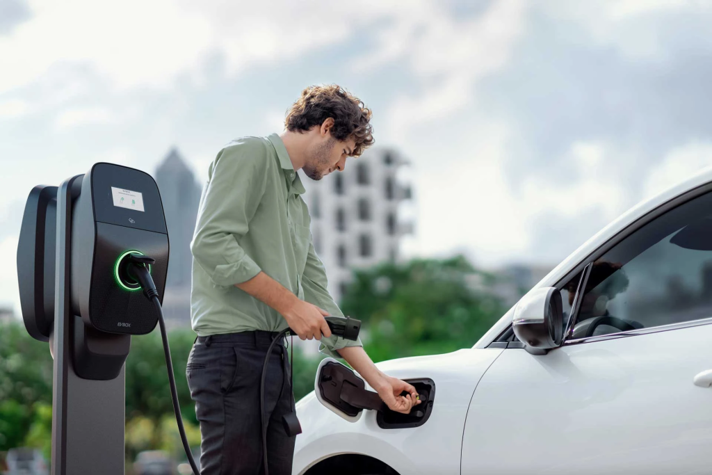 Curly-haired man charging his car