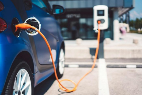 A blue car is charging at a commercial charging station