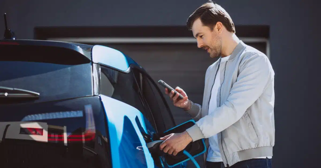 A man is charging his blue car